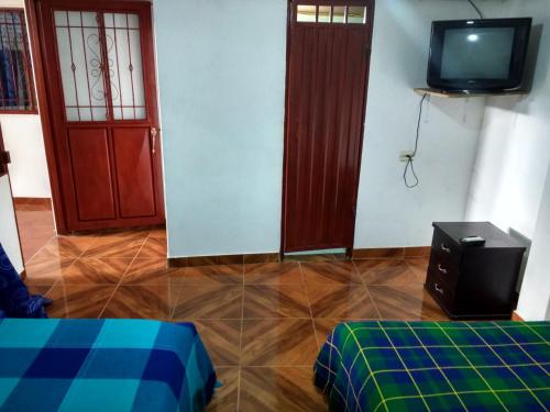 a room with two doors and a tv and a floor at Hotel El Turista in San Agustín