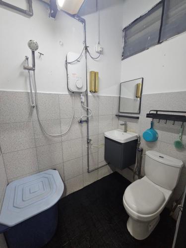 a bathroom with a shower and a toilet and a sink at Homestay Una Kangar in Kangar