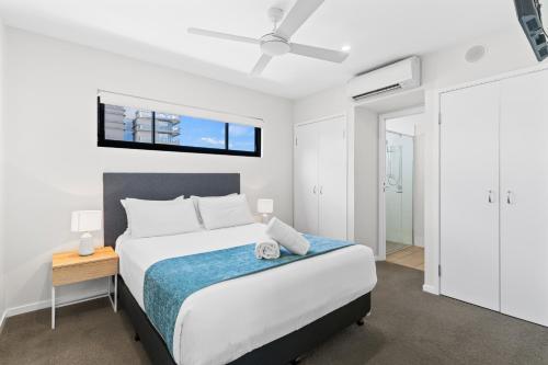 a bedroom with a bed and a window on the wall at Direct Collective - Sea Breeze Mooloolaba in Mooloolaba