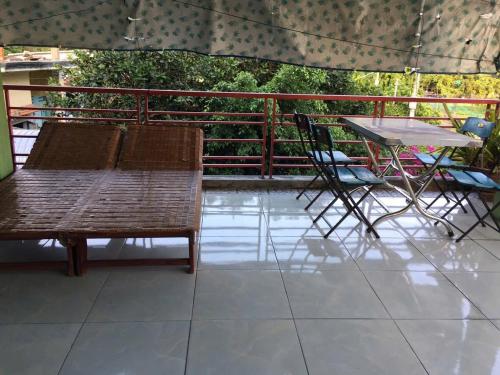 a patio with a table and chairs and an umbrella at Tam hien ho in Tân Hiệp
