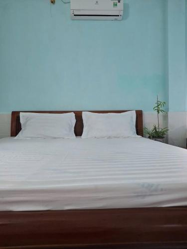 a bed with white sheets and pillows on it at Tam hien ho in Tân Hiệp