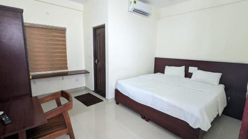 a bedroom with a bed and a window in it at Masterkey stay in Kakkanad