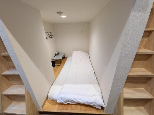 a small room with a bed in the wall at Hiroshima Saijo Youth Hostel in Higashihiroshima