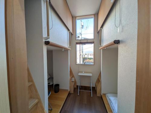 a small room with a bed and a window at Hiroshima Saijo Youth Hostel in Higashihiroshima