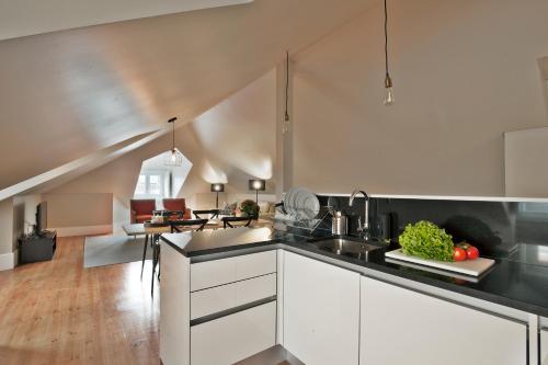 a kitchen with white cabinets and a counter top at Lisbon Five Stars Apartments Bica in Lisbon
