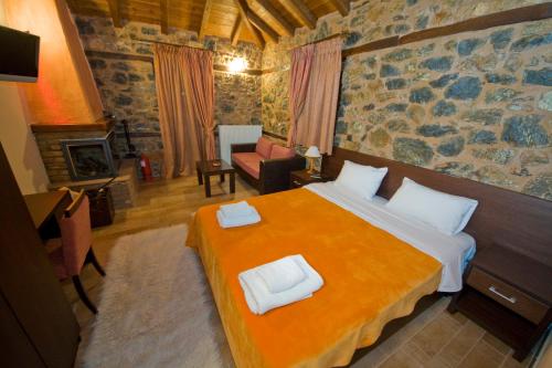 a bedroom with a large bed and a living room at Xenonas Piperitsa in Palaios Agios Athanasios