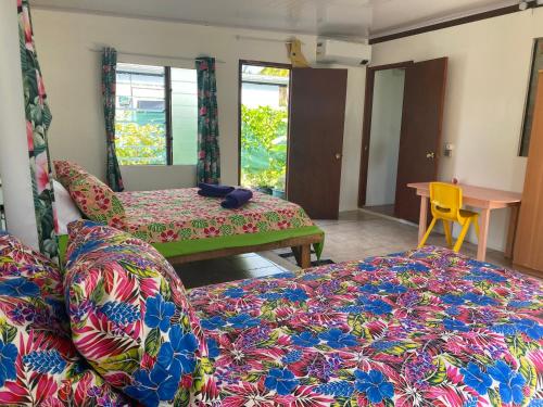 a room with two beds and a couch and a table at Punahere lodge Ohotu in Rangiroa