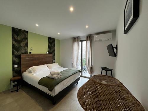 a bedroom with a bed and a table in it at Hôtel du Golfe Pinarello in Pinarellu