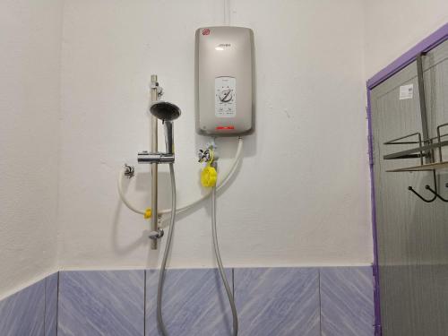 a cell phone hanging on a wall in a bathroom at Rumah Impian Bapa in Semporna