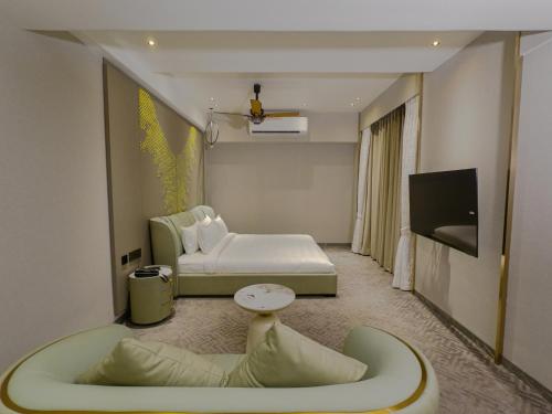 a hotel room with a bed and a tv at SVS Bhawan in Ulhāsnagar