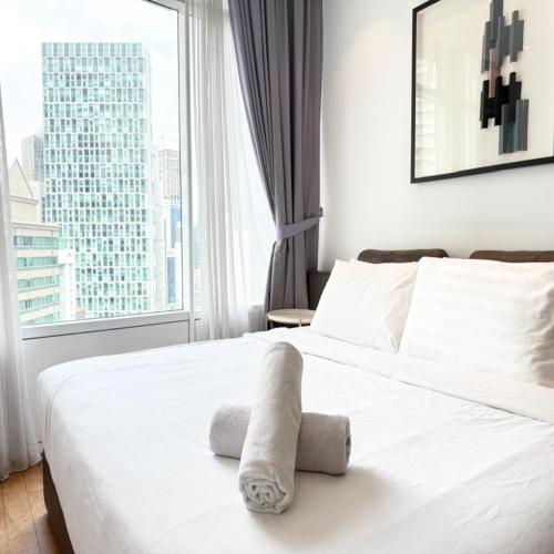 a bedroom with a white bed with a window at Vortex by klcc view in Kuala Lumpur