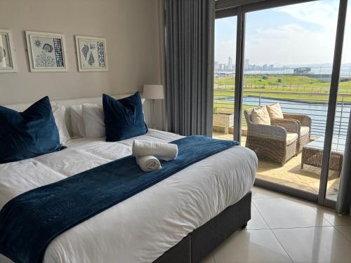 a bedroom with a bed with a blue blanket on it at Durban Point Waterfront, 304 The Quays in Durban