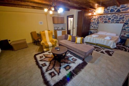a living room with a couch and a bed at Xenonas Piperitsa in Palaios Agios Athanasios