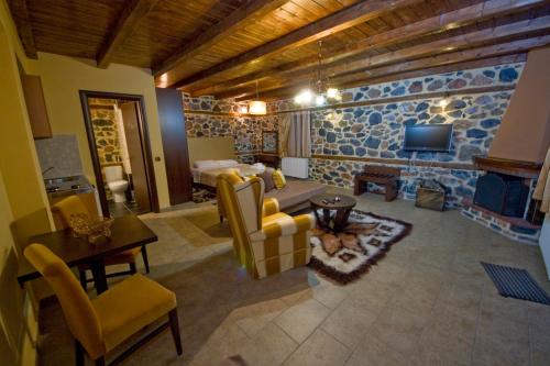 a large living room with a stone wall at Xenonas Piperitsa in Palaios Agios Athanasios