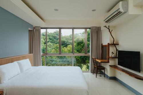 a bedroom with a bed and a large window at Toptai Kenting BY REINDEER in Kenting