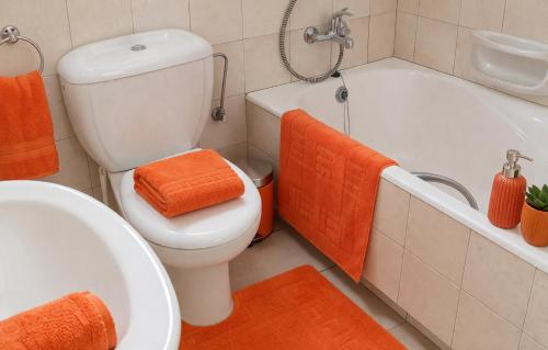 an orange bathroom with a toilet and a bath tub at Beach Shack in Khlorakas