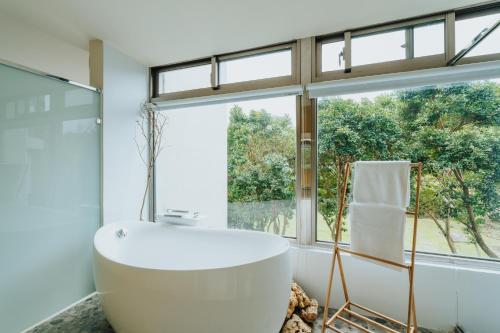 a bathroom with a large tub and a window at Toptai Kenting BY REINDEER in Kenting