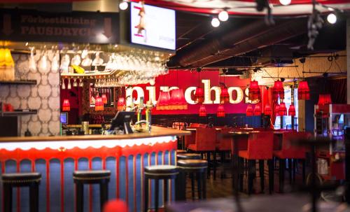 a bar with red bar stools and a neon sign at Best Western Hotel Savoy in Karlstad