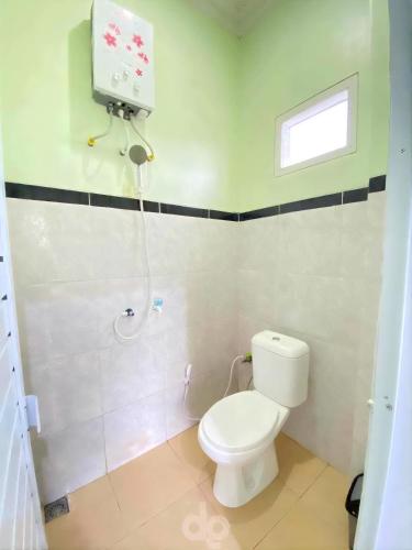 a bathroom with a white toilet and a shower at Homestay Gavilla Dieng in Diyeng