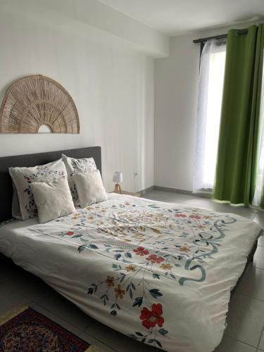 a bedroom with a large bed with a floral bedspread at Résidence Le Carillon in Saint-André