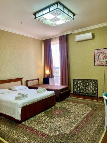 a hotel room with two beds and a window at Hotel Vardonze in Bukhara