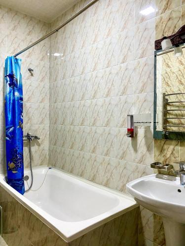 a bathroom with a bath tub and a sink at Hotel Vardonze in Bukhara