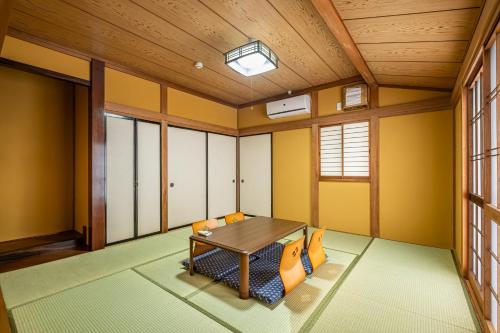 a dining room with yellow walls and a wooden ceiling at Dream Bridge Fuji House in Fuji