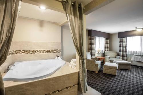 a large bathroom with a tub and a living room at Clarion Inn Renton-Seattle in Renton