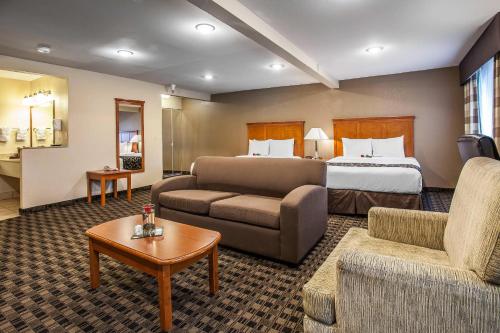 a hotel room with a bed and a couch at Clarion Inn Renton-Seattle in Renton