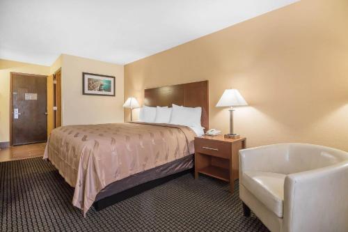 a hotel room with a bed and a chair at Quality Inn Janesville North in Janesville