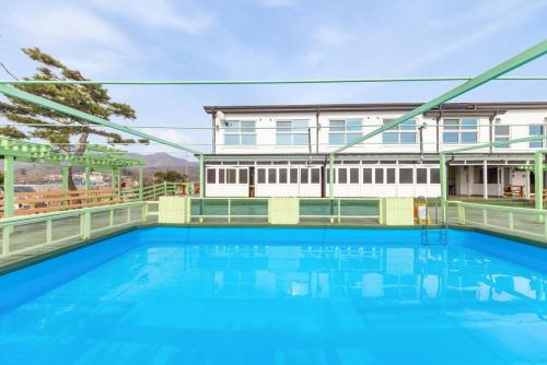 a large swimming pool in front of a house at Abientot Spa Pension Ganghwa in Incheon