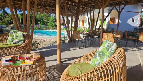 a patio with wicker chairs and a table and a pool at Mangoverde Guesthouse in Moalboal
