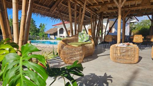 a patio with wicker chairs under a pavilion at Mangoverde Guesthouse in Moalboal