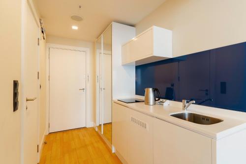 a kitchen with a sink and a white counter top at Guest Favorite Sea View Apartments Batumi in Batumi