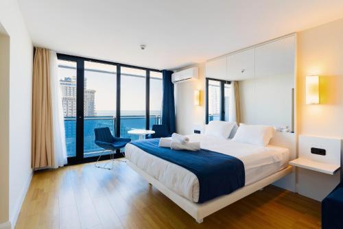 a bedroom with a large bed and a large window at Guest Favorite Sea View Apartments Batumi in Batumi