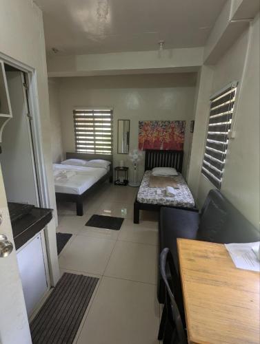 a small room with two beds and a couch at Casa Feliz Apartments Baguio in Baguio