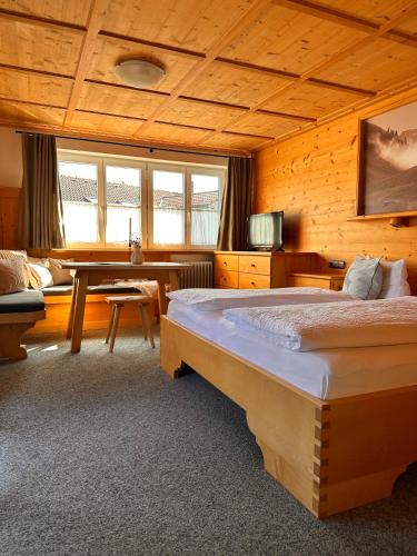 a bedroom with a bed and a desk in a room at Das Tannacker - Ferienwohnungen Hartmann in Fischen
