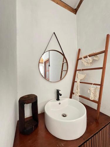 a bathroom with a white sink and a mirror at Satha private villa Dieng 3 in Banjarnegara