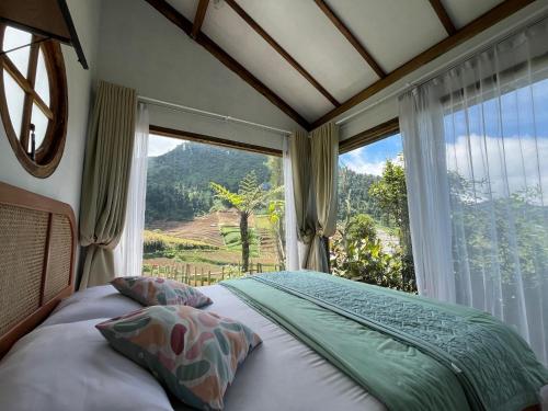 a bedroom with a bed in front of a window at Satha private villa Dieng 3 in Banjarnegara