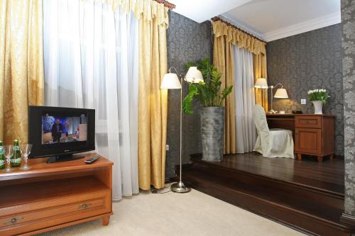 a living room with a television on a wooden table at Hotel Imperium in Chełmża