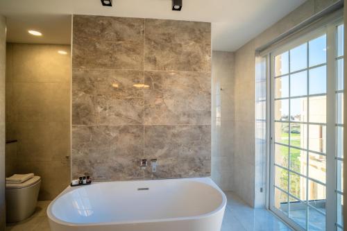 a bath tub in a bathroom with a window at Pietro Boutique Hotel and Villas in Għarb