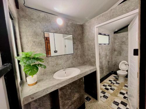 a bathroom with a sink and a potted plant at Oasis forest garden in Ban Takuk Nua