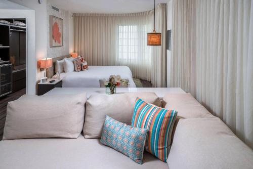 a living room with two beds and a couch with pillows at The Marlin Hotel in Miami Beach