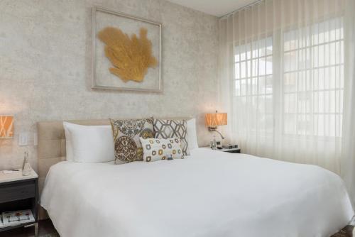 a bedroom with a large white bed and a window at The Marlin Hotel in Miami Beach