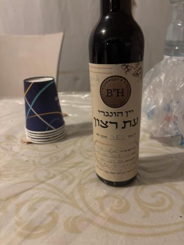 a bottle of wine sitting on top of a table at חאן הכנסת אורחים B''H village שומר שבת in Nevatim