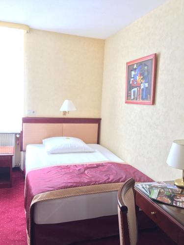 a hotel room with a bed and a desk at Frischbier's Gästezimmer in Schmelz-Primsweiler