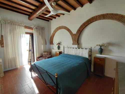 a bedroom with a bed and a ceiling fan at Il Peppolo Country House in Pelago