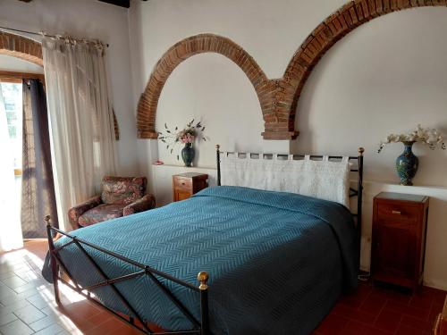 a bedroom with a bed with an arch above it at Il Peppolo Country House in Pelago