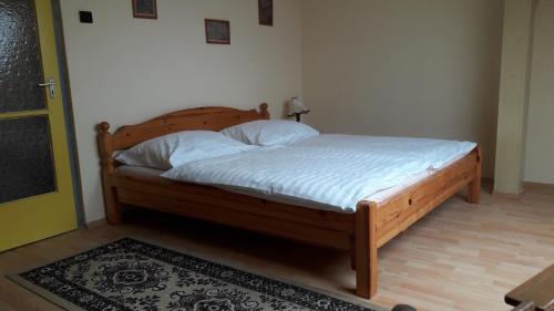 ザーンカにあるZánka-Balatonのベッドルーム1室(白いシーツが備わる木製ベッド1台付)