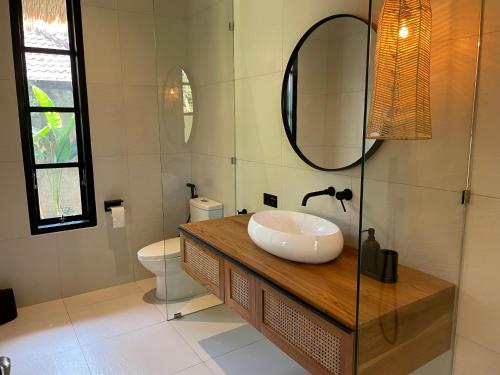 a bathroom with a sink and a mirror at Villa Rawarawa Private Beachfront in Central of Lovina by GEMA MANAGEMENT BALI in Lovina